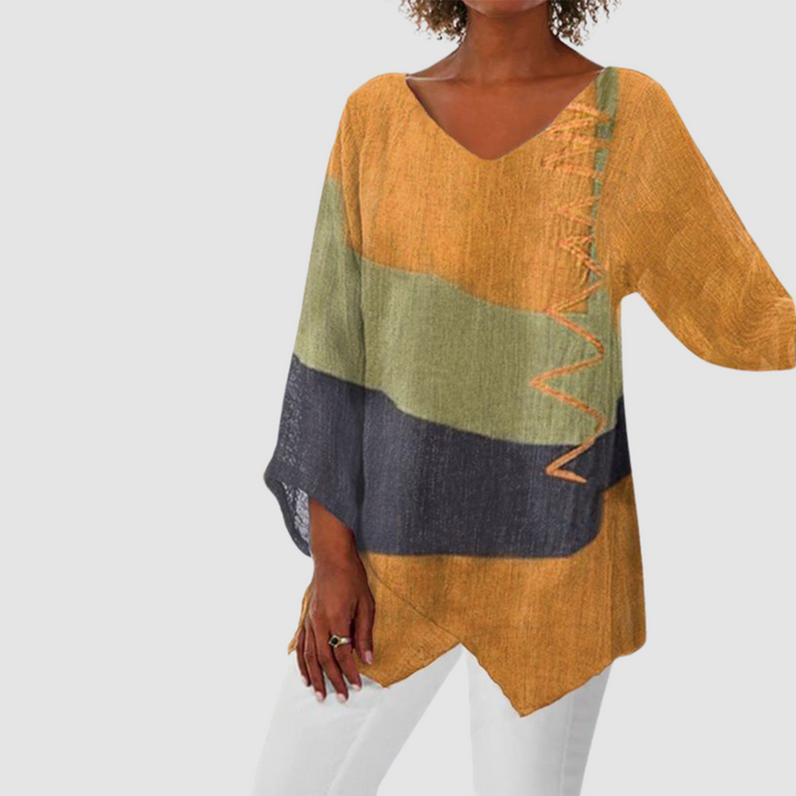 Warm ochre, green, and black loose breathable shirt with asymmetrical hem in studio setting.