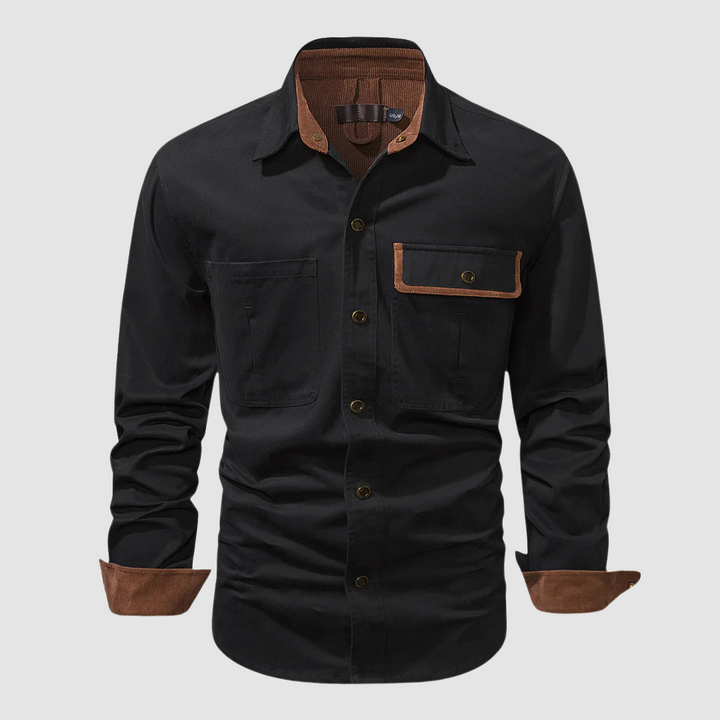 Black long-sleeved shirt with brown inner collar and cuffs, front pocket detail, studio setting.