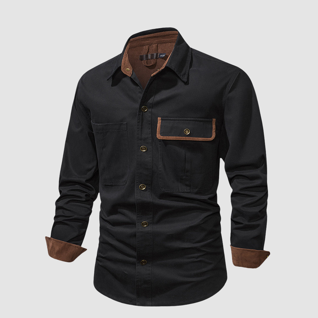 Black long-sleeved shirt angled view, brown accents, front pocket detail, studio background.