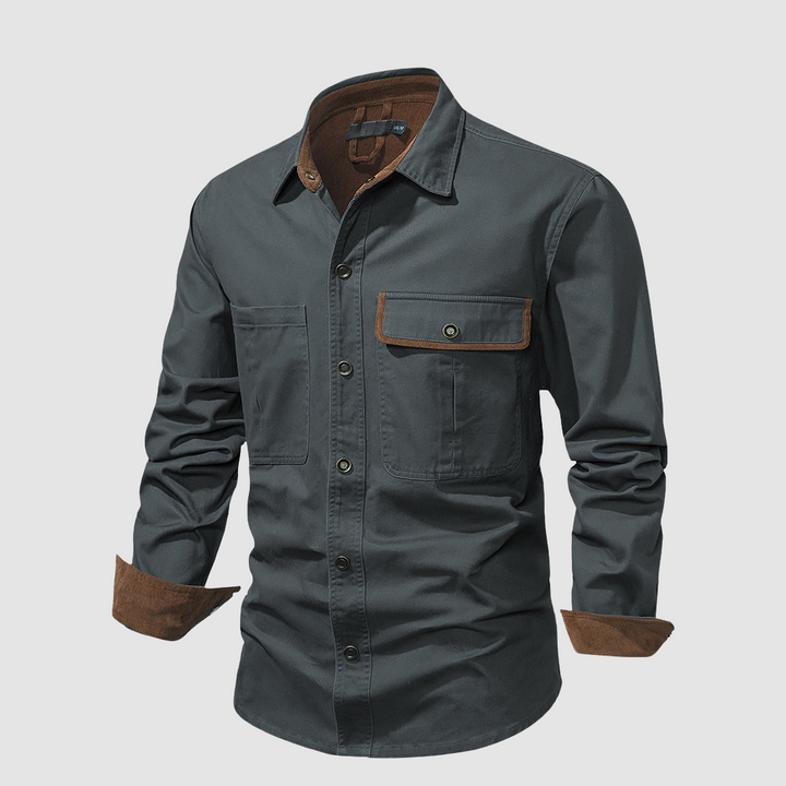 Grey shirt angled view, brown inner accents, pocket detail, studio background.