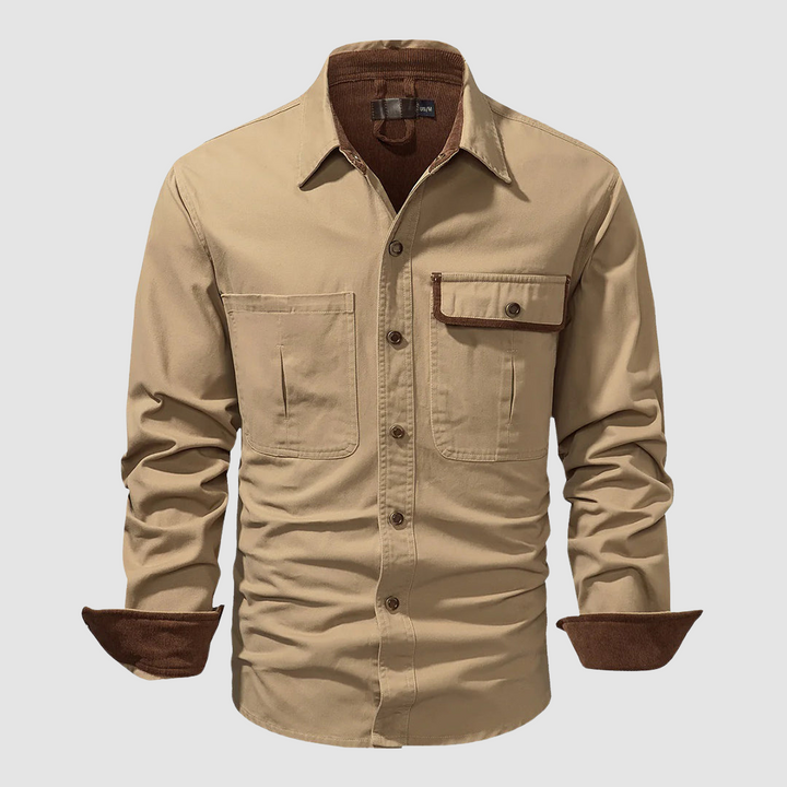 Tan long-sleeved shirt with brown inner collar and cuffs, front pocket, studio background.