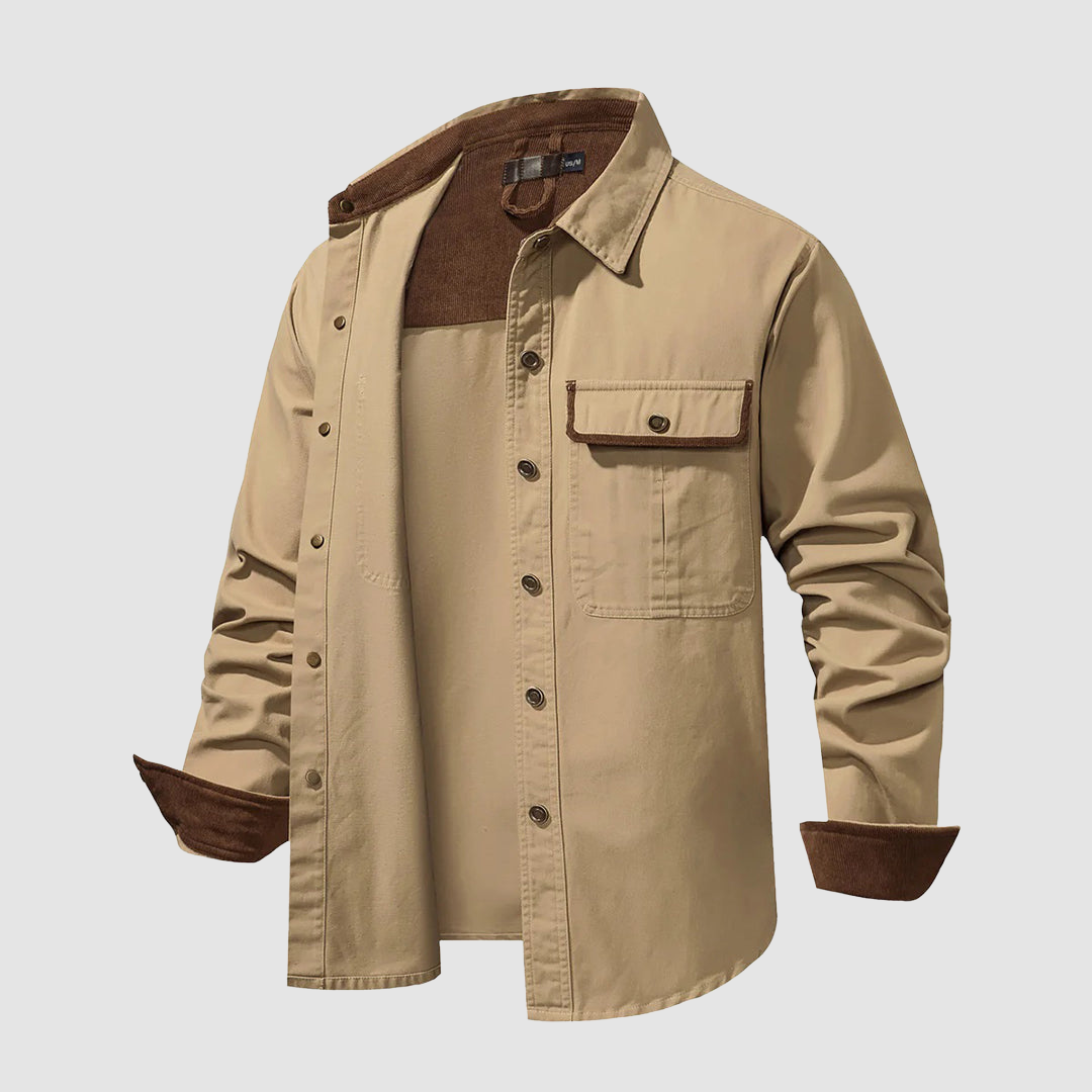 Tan shirt partially unbuttoned, brown inner collar, pocket detail, indoor studio.