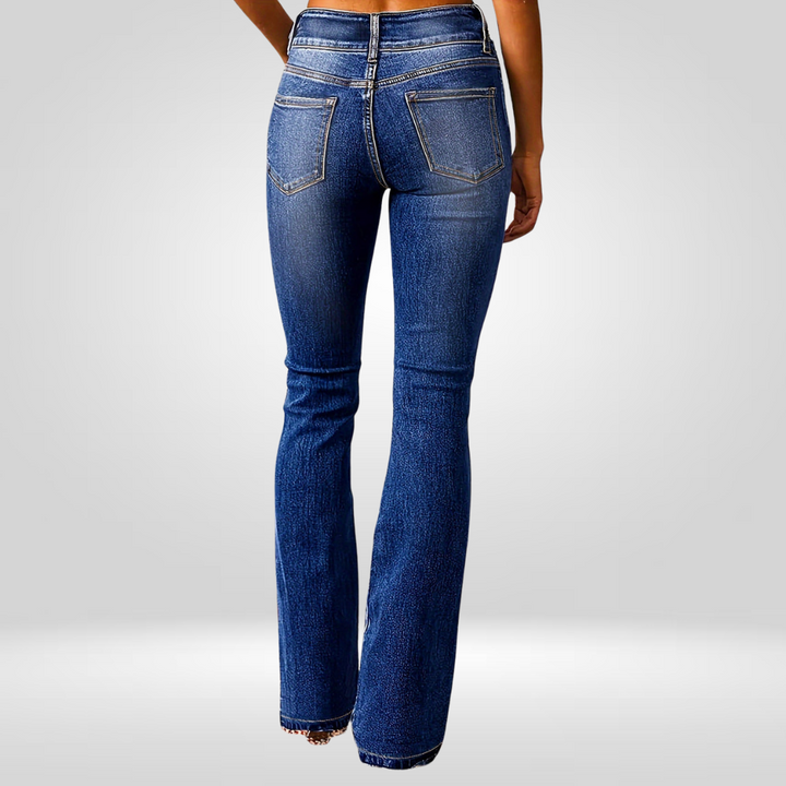 Rear view of high-flared blue jeans worn by a model in a studio setting.