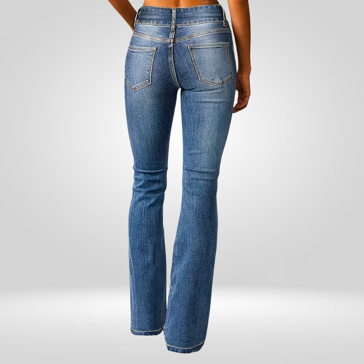 Rear view of high-flared blue jeans worn by a model in a studio setting.
