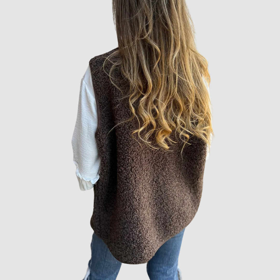 Back view of a brown textured vest over a white shirt, highlighting curly hair in a studio setting.