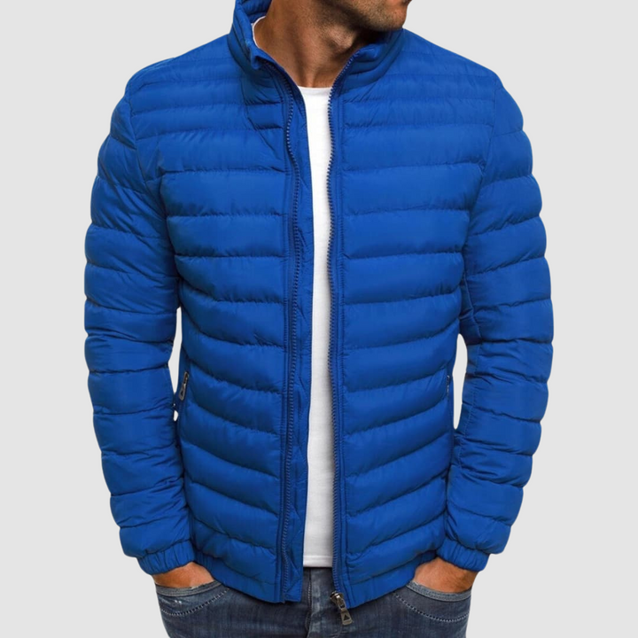Blue lightweight summer jacket with a front zipper, modeled with hands in pockets against a plain background.