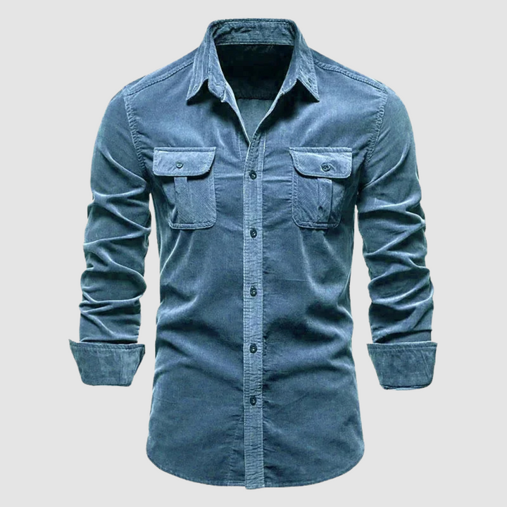 Light blue corduroy shirt with buttoned flap pockets and rolled sleeves, displayed on a light gray background.