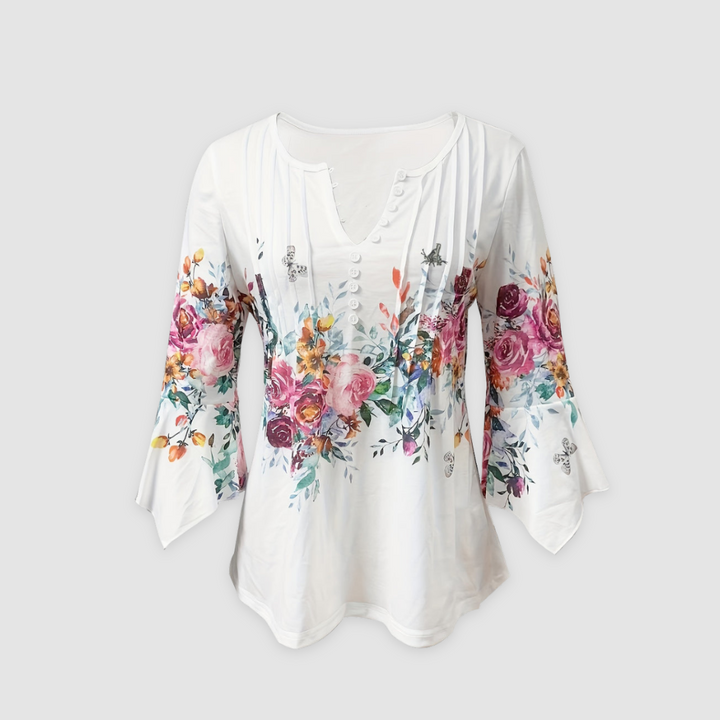 Front view of a floral blouse with colorful flower pattern and bell sleeves, displayed in a studio setting.