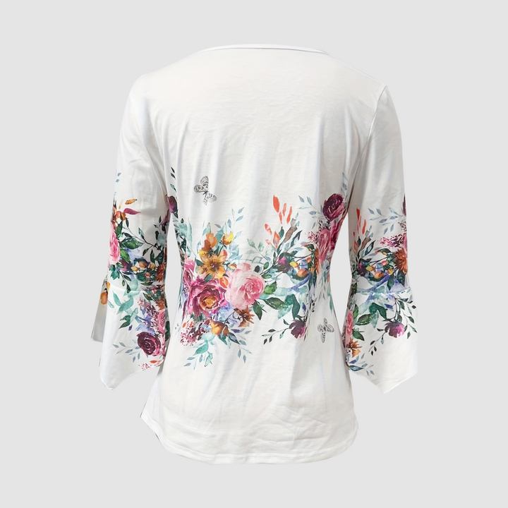 Back view of a floral blouse with colorful flower pattern and bell sleeves, displayed in a studio setting.