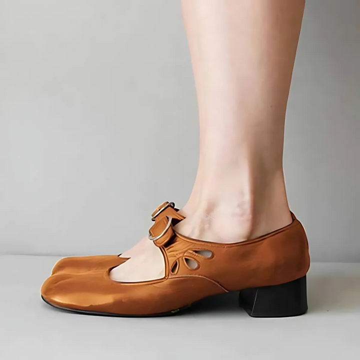 Side view of brown leather sandals with buckle on feet in a neutral setting.