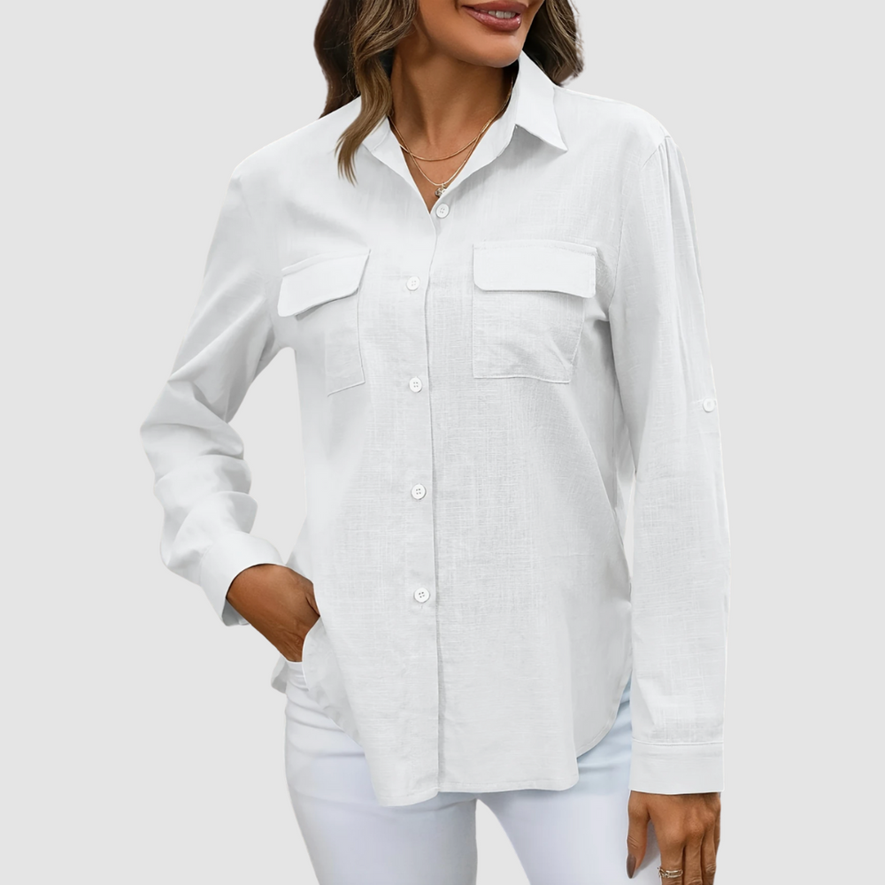 White pocket blouse with long sleeves and front pockets, hand in pocket, studio background.