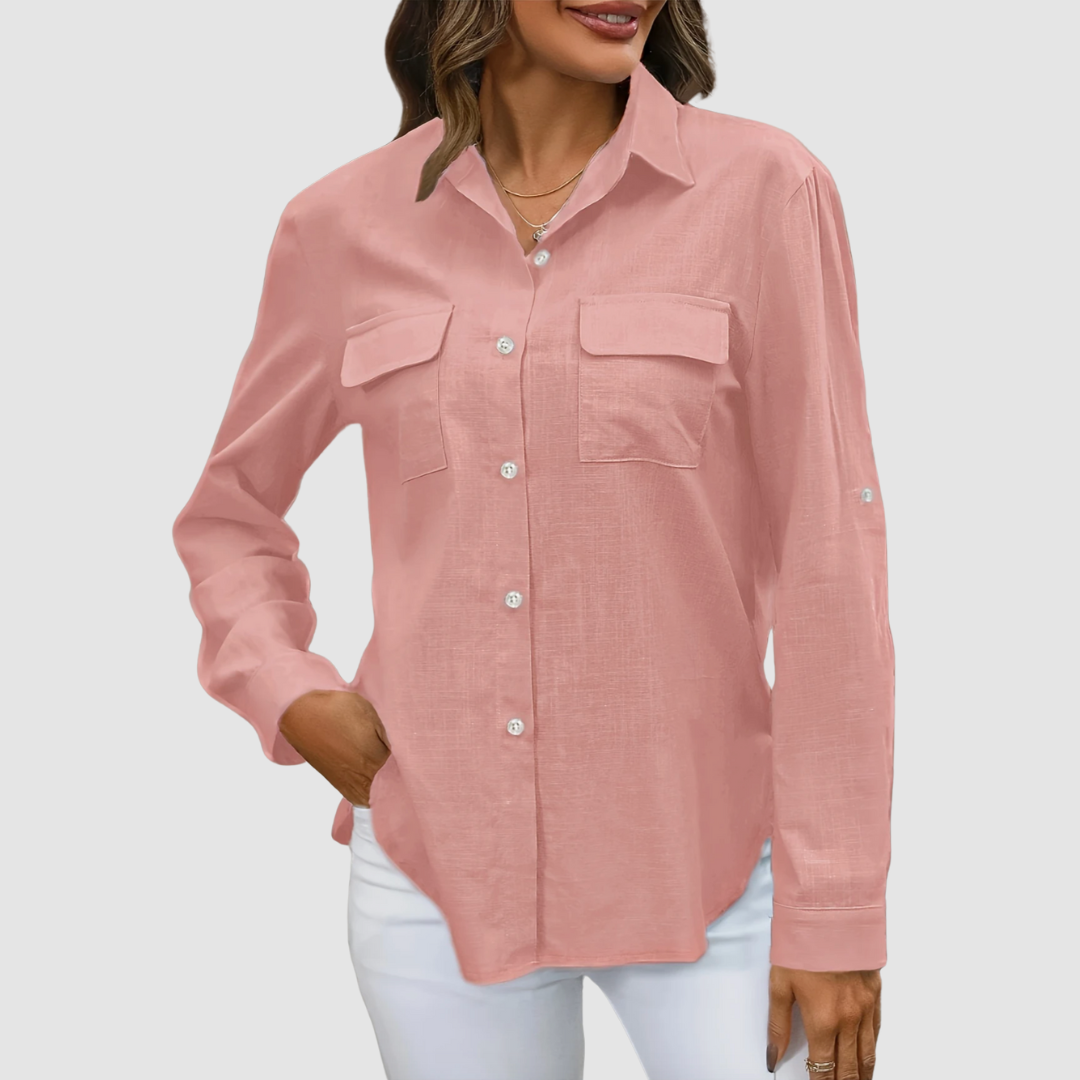 Pink pocket blouse with long sleeves and front pockets, hand in pocket, studio background.