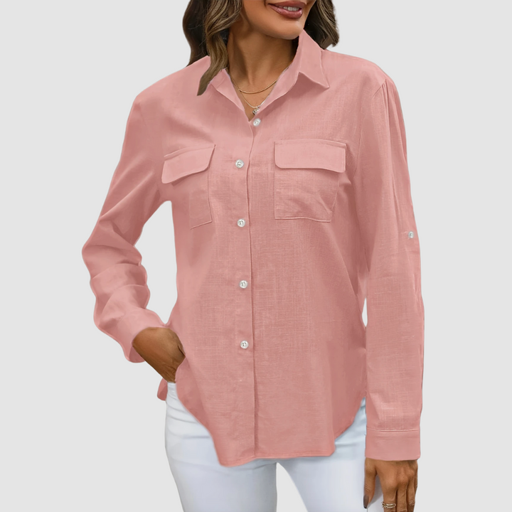 Pink pocket blouse with long sleeves and front pockets, hand in pocket, studio background.