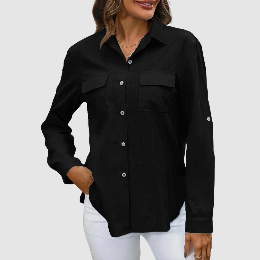 Black pocket blouse with long sleeves and front pockets, hand in pocket, studio background.