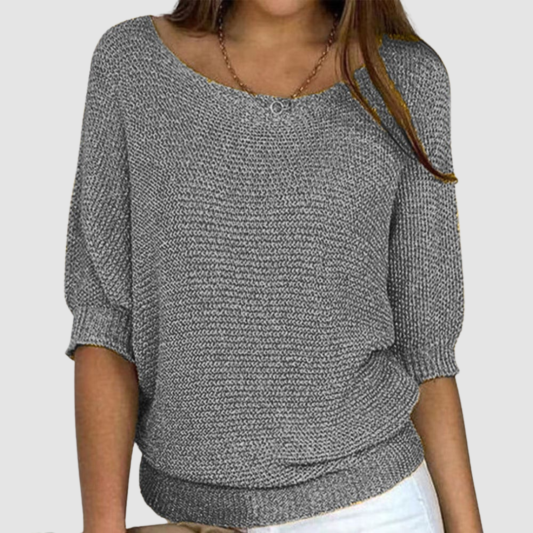 Gray knitted sweater with a boat neckline and three-quarter sleeves, worn by a model against a plain background.