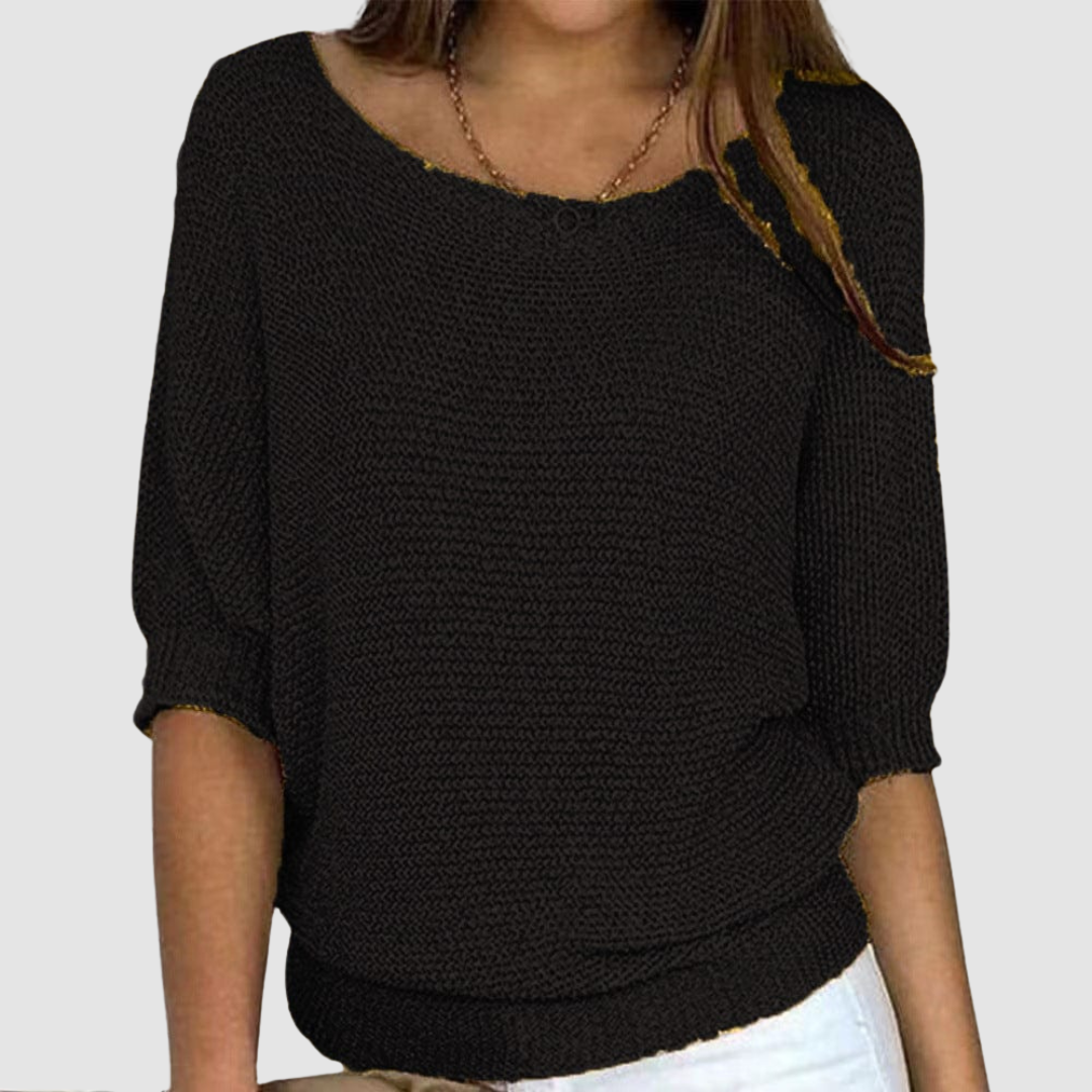 Black knitted sweater with a boat neckline and three-quarter sleeves, worn by a model against a plain background.