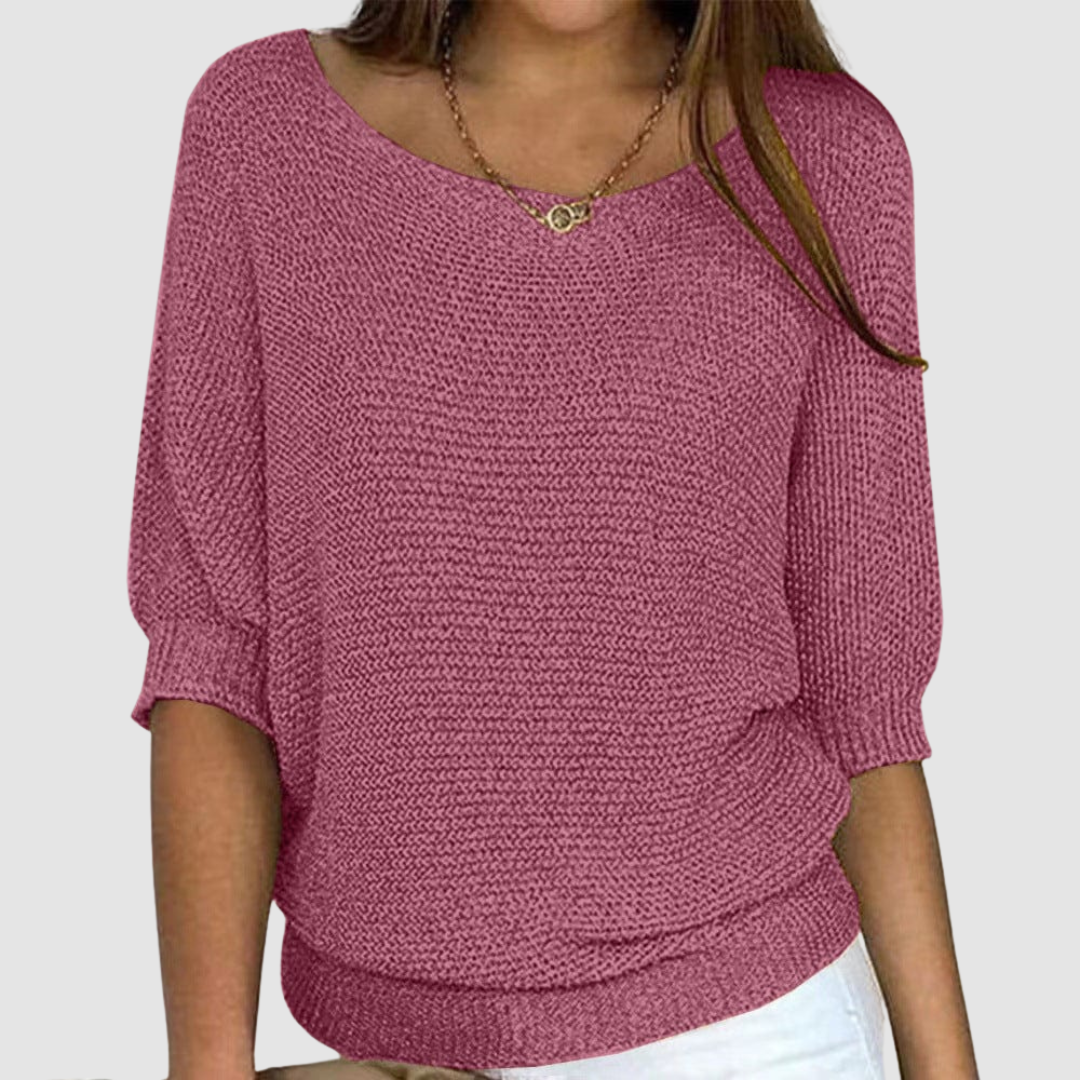 Pink knitted sweater with a boat neckline and three-quarter sleeves, worn by a model against a plain background.