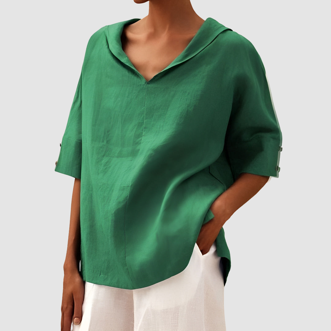 Bright green blouse featuring a V-neck and short sleeves, styled with white pants, studio scene.