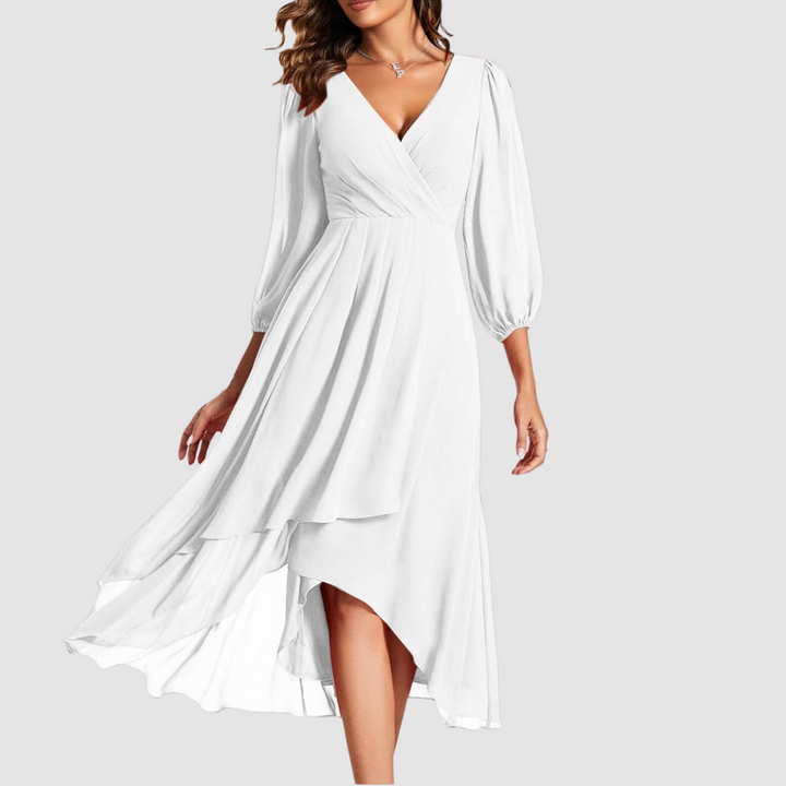 Elegant V-neck long dress in pure white, with flowing layers and three-quarter sleeves, studio setting.