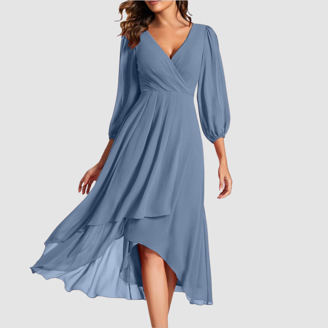 Elegant V-neck long dress in soft blue, featuring flowing layers and three-quarter sleeves, studio setting.