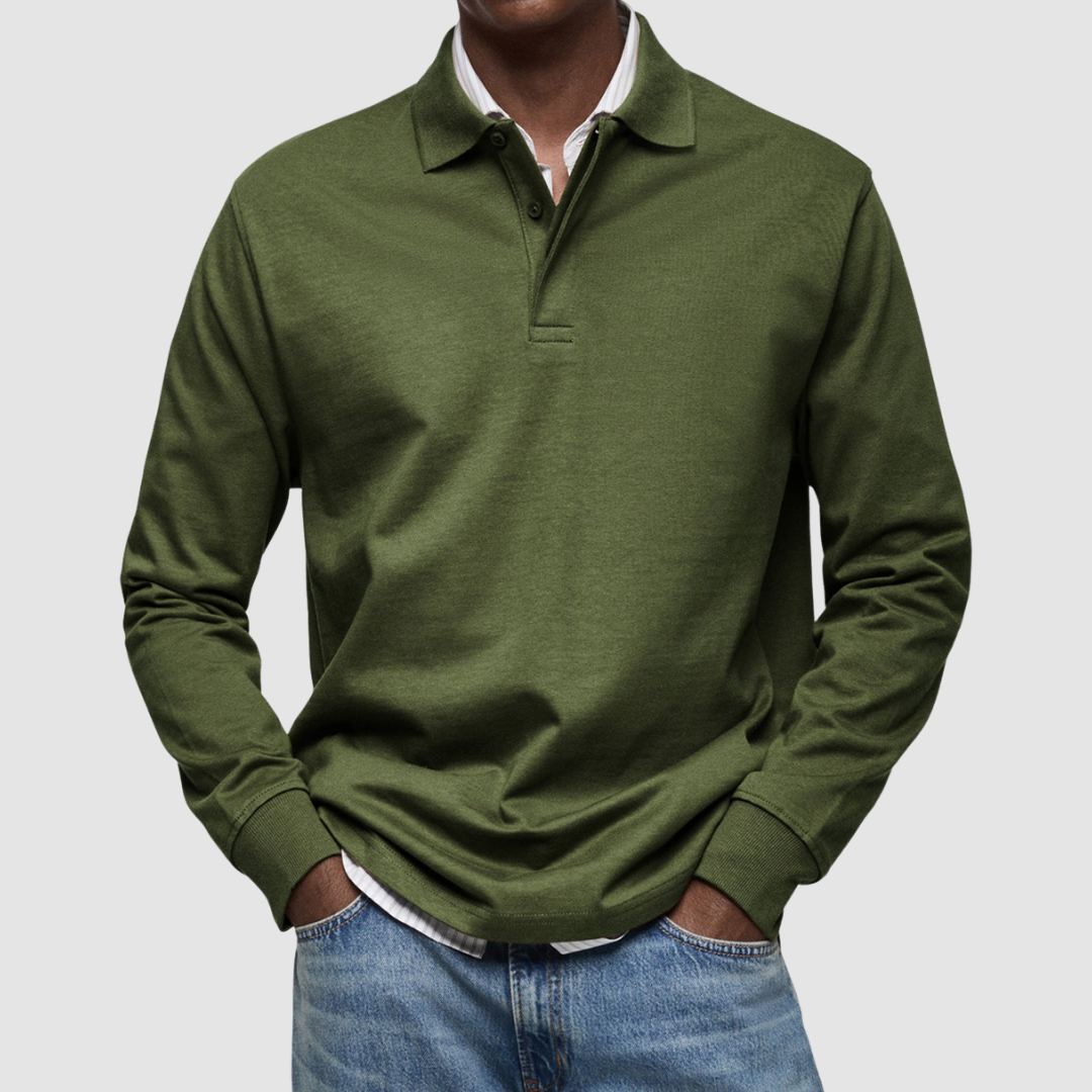 Olive long sleeve polo shirt with button collar, worn over striped shirt, paired with jeans; studio setting.