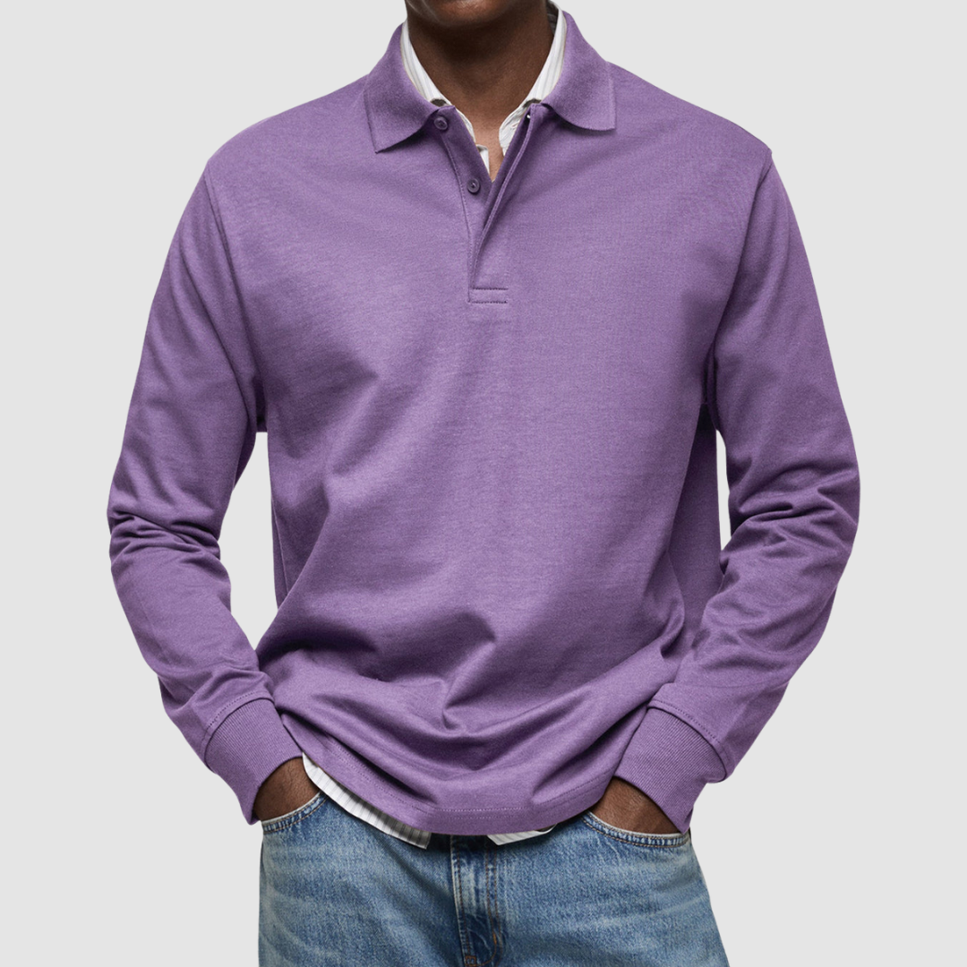 Purple long sleeve polo shirt with button collar, worn over striped shirt, paired with jeans; studio setting.