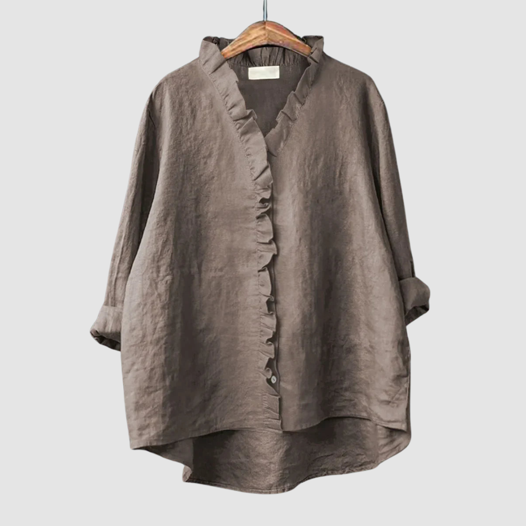 Earthy brown blouse with ruffled collar and button closure on wooden hanger, set against a light gray background.