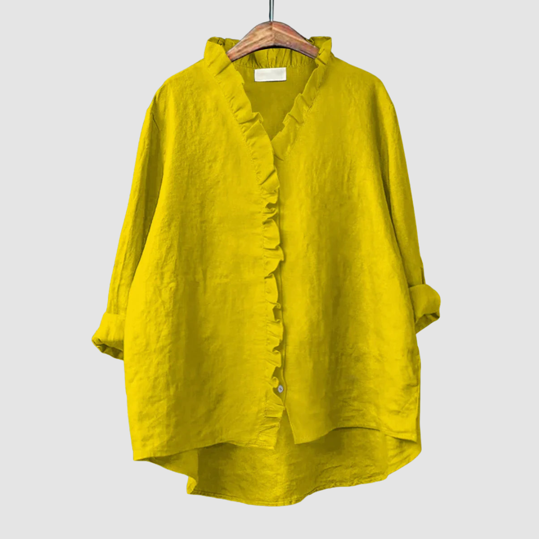 Vibrant yellow blouse with ruffled collar and button closure on wooden hanger, set against a light gray background.