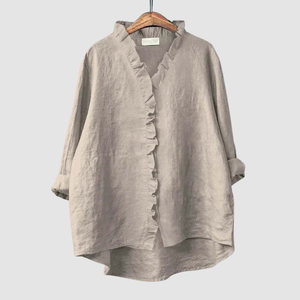 Neutral beige blouse with ruffled collar and button closure on wooden hanger, set against a light gray background.