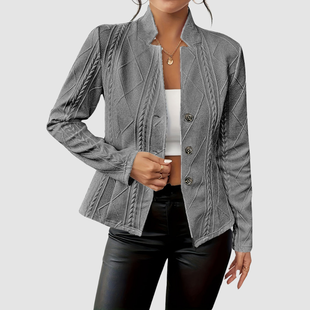 Gray textured blazer with button closure, paired with black leather pants and white top, studio setting.