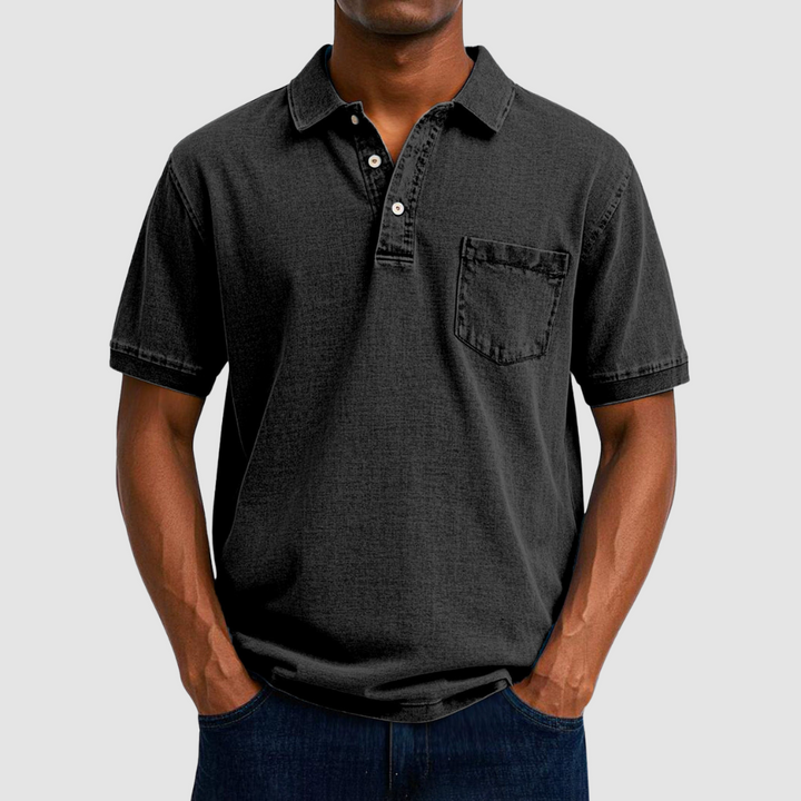 Black casual polo shirt with short sleeves and buttoned collar, modeled in a studio background.