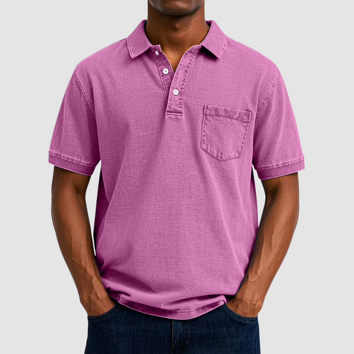 Pink casual polo shirt with short sleeves and buttoned collar, modeled by a person in a studio setting.