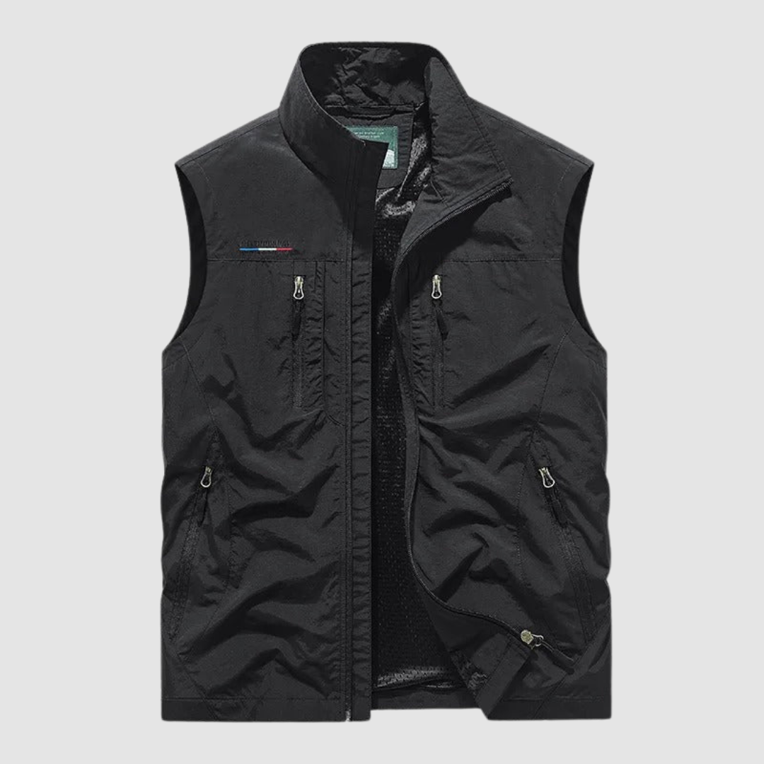 Black breathable utility vest with zipper pockets on a light gray background.