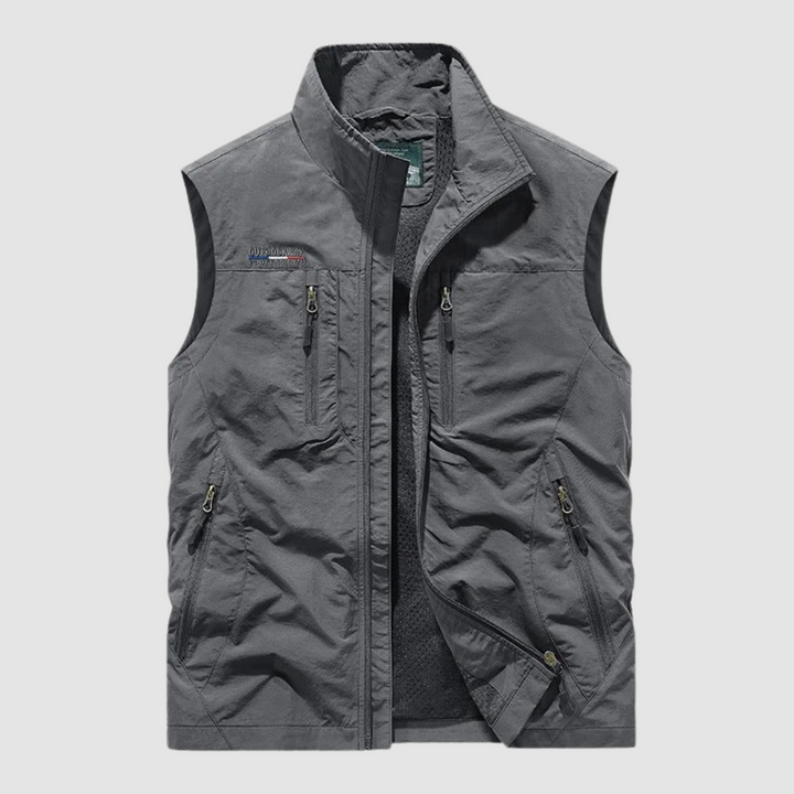 Gray breathable utility vest with zipper pockets on a light gray background.