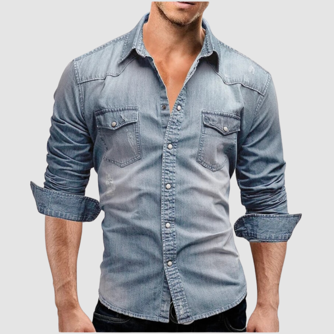 Light blue denim shirt worn by a model, with folded sleeves and button-up front in a studio setting.