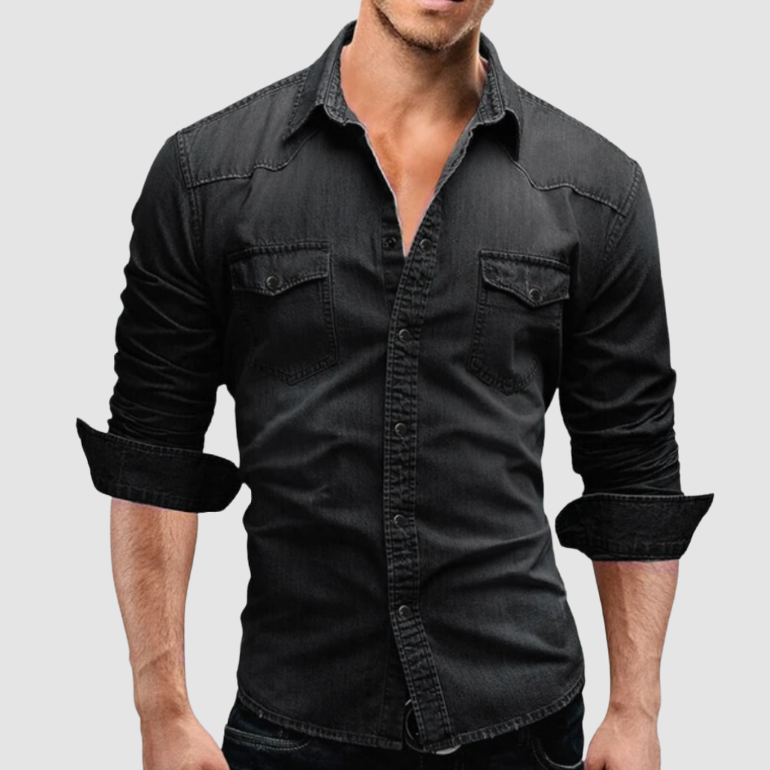 Black denim shirt worn by a model, with folded sleeves and button-up front in a studio setting.