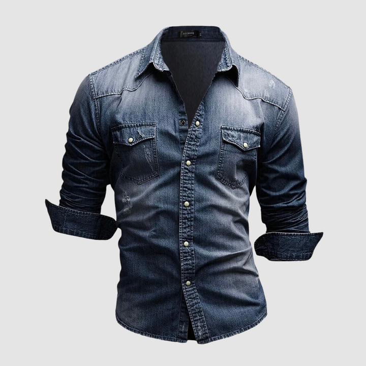 Dark blue denim shirt with folded sleeves and button-up front displayed in a studio on a white background.