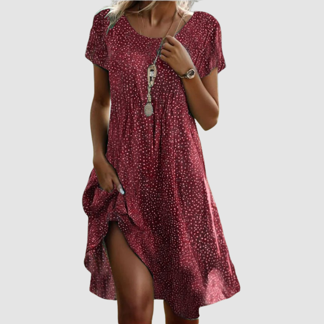 Red floral summer dress with a comfortable cut and short sleeves, styled in a studio scene.