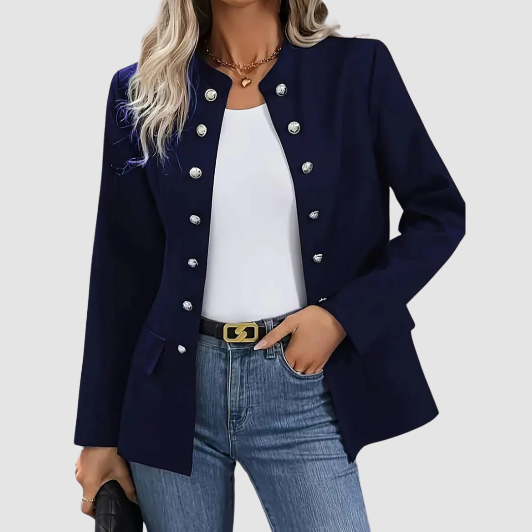 Navy blazer with silver buttons, worn over a white top and jeans, paired with a black belt in a studio setting.