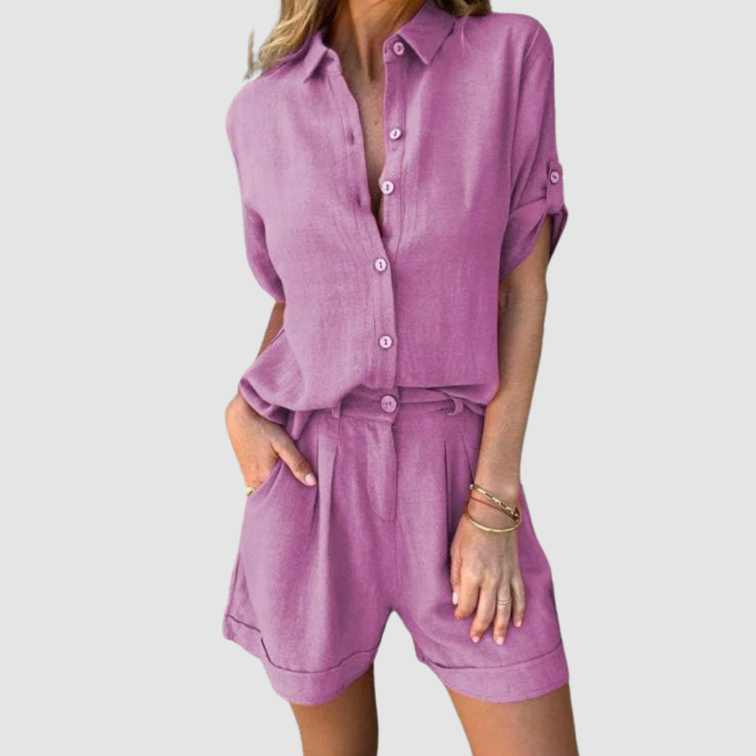 Woman wearing a purple summer set featuring a button-up blouse and shorts, studio background.