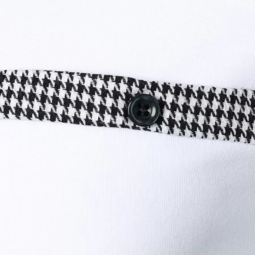 Close-up of a houndstooth patterned trim with a black button on a white polo shirt.