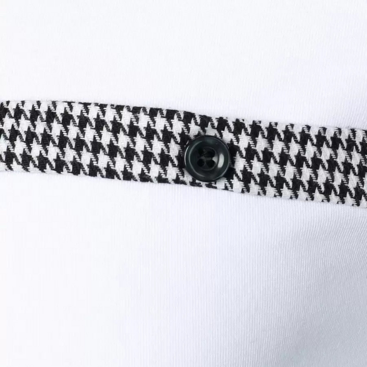 Close-up of a houndstooth patterned trim with a black button on a white polo shirt.
