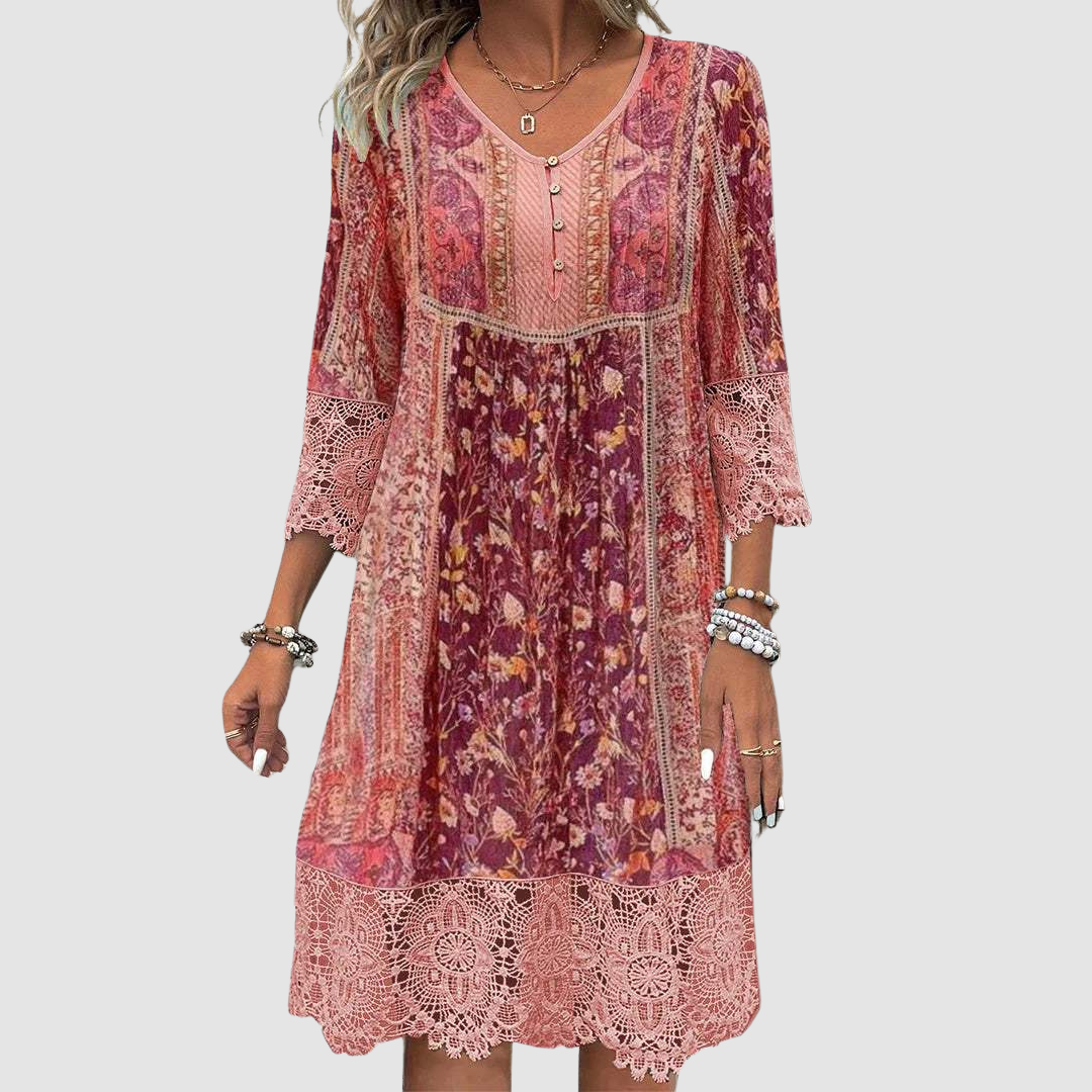 Front view of boho dress in red tones with floral pattern, lace details, worn by model, plain background.