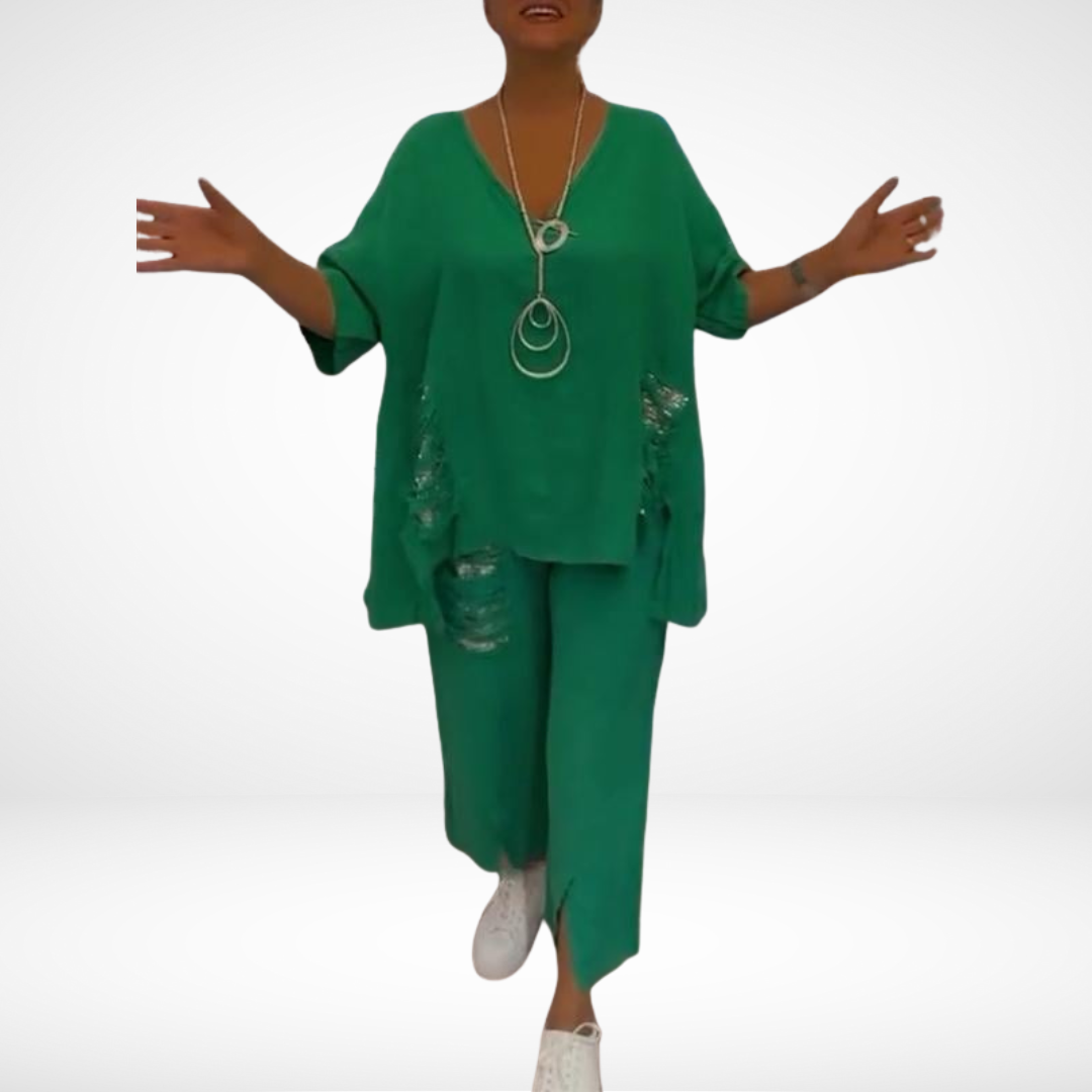 Model in green two-piece set with layered neckline accessories, in a white background.