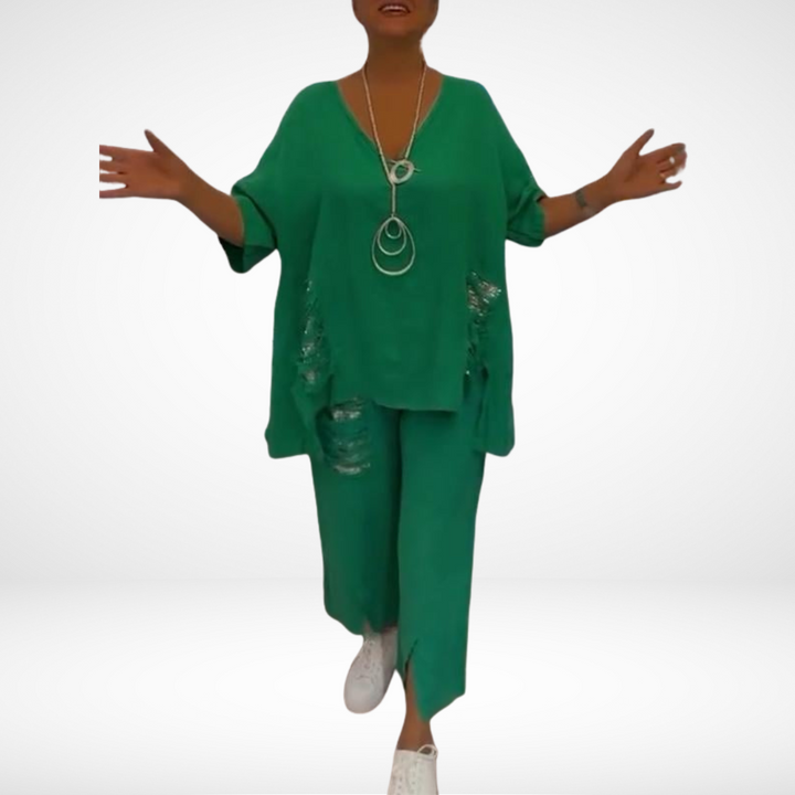 Model in green two-piece set with layered neckline accessories, in a white background.