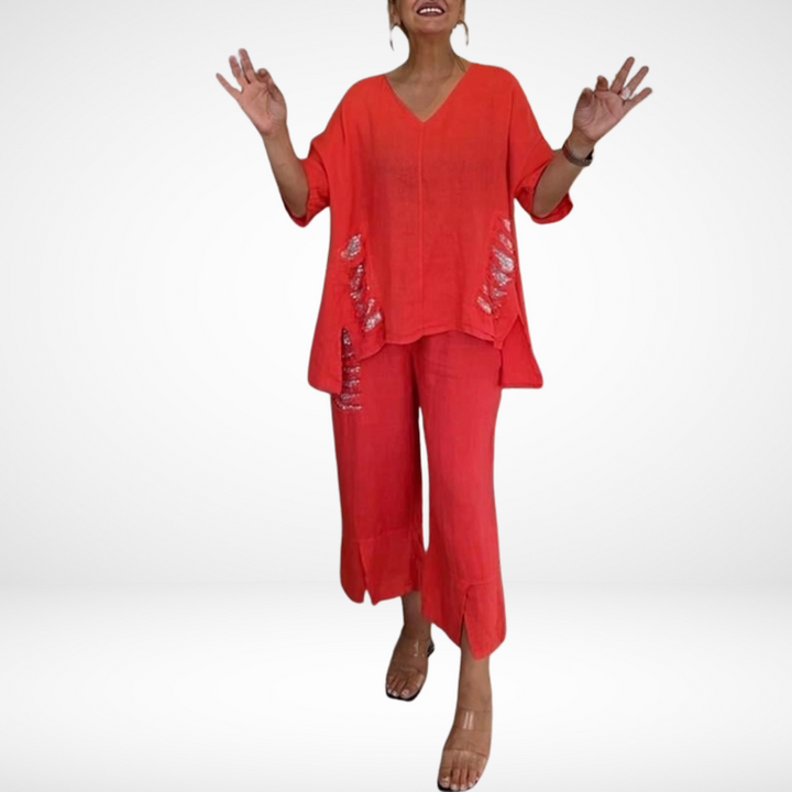 Model wearing a red two-piece outfit with distressed details, set in a white studio.