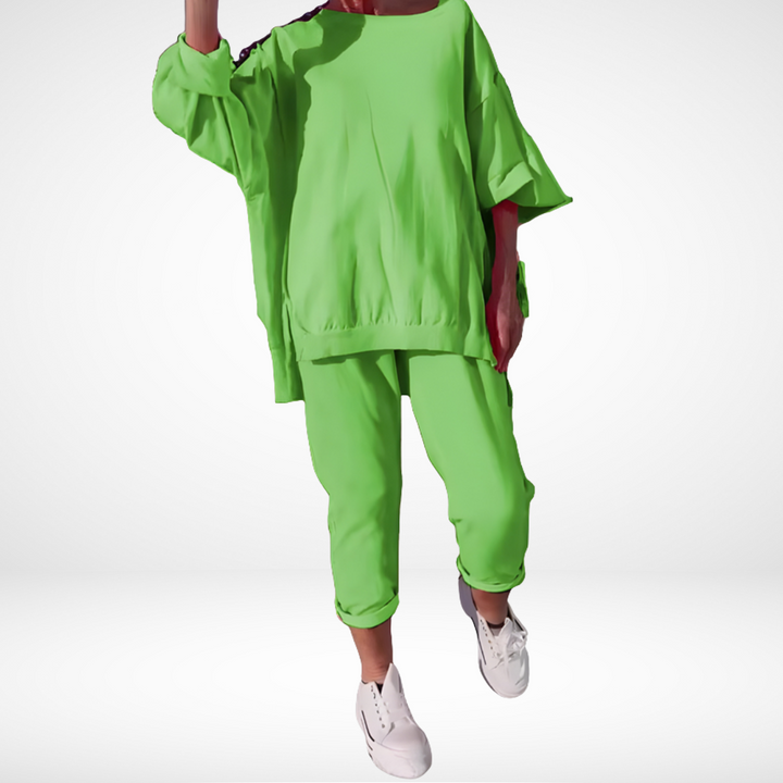 Lime green lounge set with oversized top, cuffed pants, and white sneakers, displayed in a bright studio.