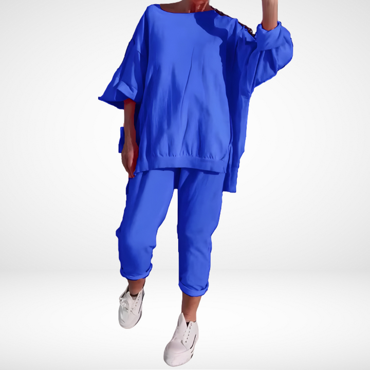 Royal blue lounge set with relaxed top and cropped pants, modeled with white sneakers in a studio environment.
