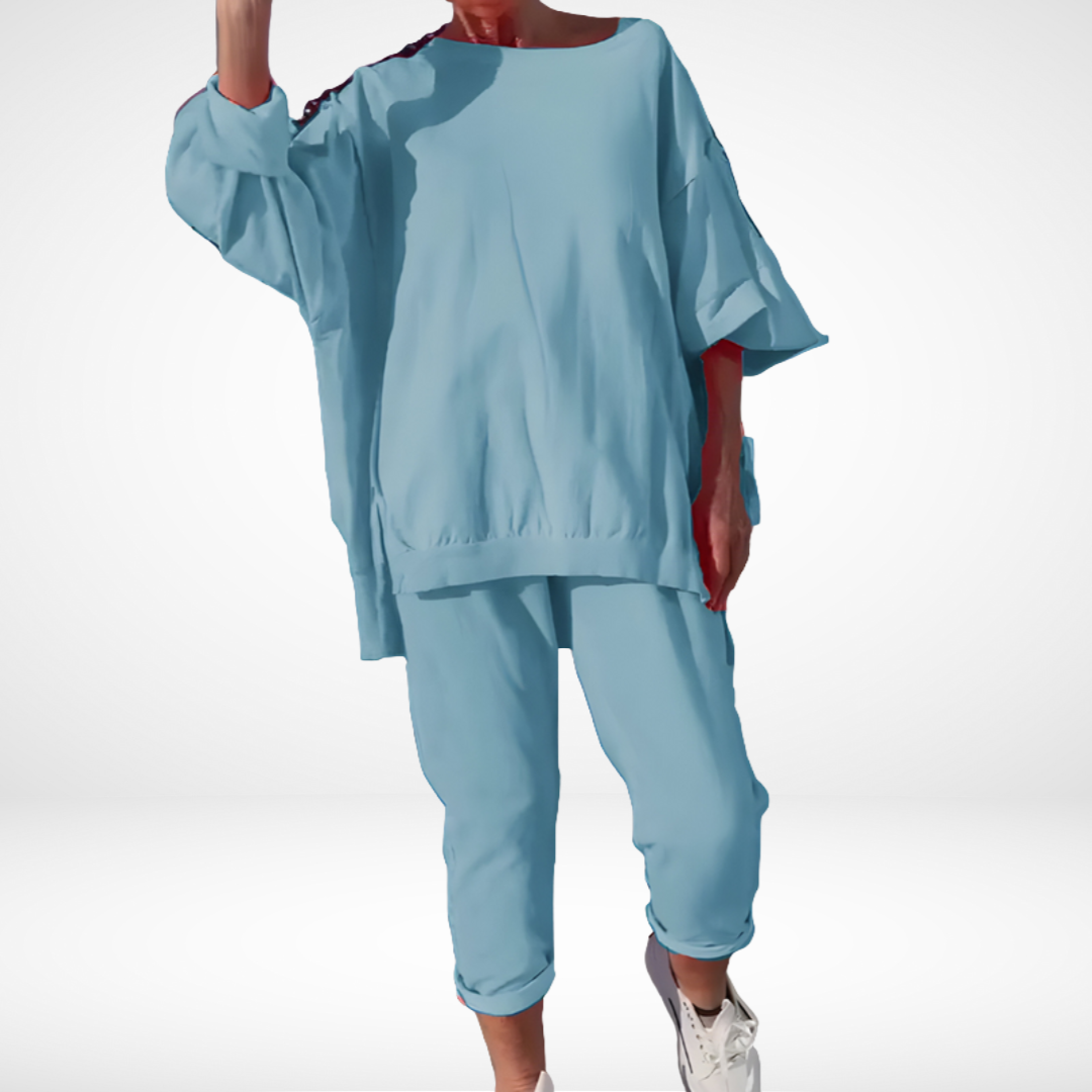 Sky blue comfort lounge set with a loose top and rolled-up pants, paired with sneakers on person in studio.
