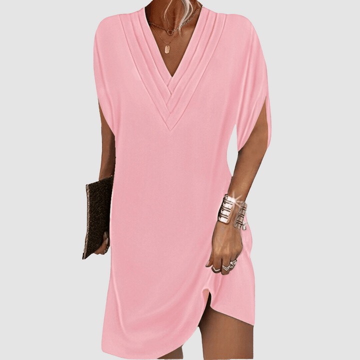 Soft pink half-sleeve dress featuring a V-neck, displayed on a light grey background.